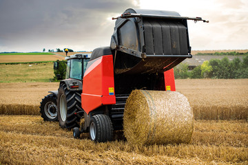 farmer in fields making straw bales