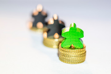 illustration of envy with wooden figures on coin piles