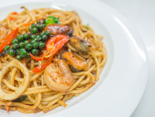 Spaghetti spicy with seafood on a white plate