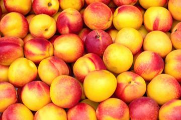 Fresh ripe nectarines or peaches at the market. Selective focus, background.