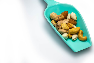 Mixed Cashews, .Almonds and .Macadamia nuts.on a green plastic spoon