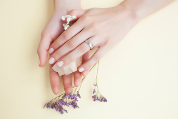 Fototapeta premium pretty perfect woman hands with white manicure and little flowers on colorful background
