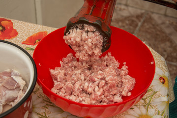 Meat grinder - process of grinding meat. Beef mince in mincing-machine. Cooking food