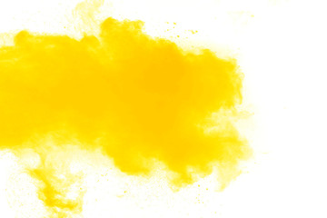 Abstract yellow orange powder explosion on white background. Freeze motion of yellow dust particles splash.