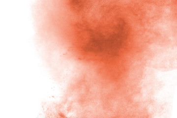 Abstract light orange powder explosion on white background. Freeze motion of light orange dust particles splash.
