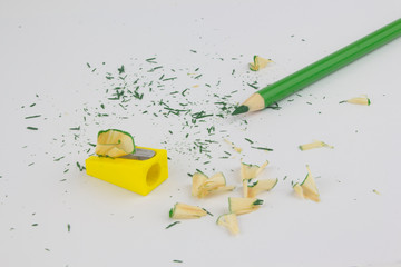 Green pencil on white background with sharpener