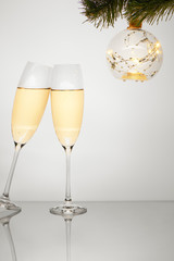 Champagne glasses and sparkle ornament on Christmas tree branch