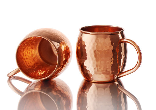 Empty copper mugs for cold and hot drinks on white