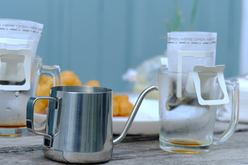 Drip or brewed coffee on wooden tabel, paper dripping bag on a cup