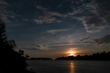 Beautiful moonrise and starry sky on the river