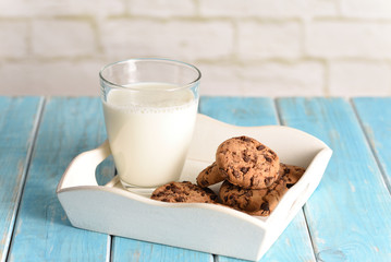 Milk and cookies on the white tray. Biscuit on the turquoise table