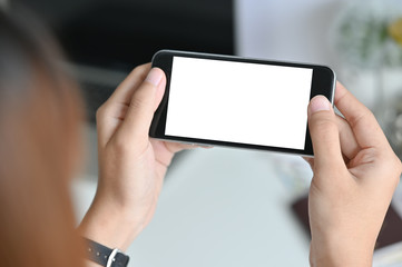 Close-up female touching blank screen smartphone on table.