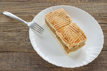 Apple pie two slices of cake on plate at wooden table