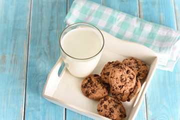 Milk and cookies on the white tray. Biscuit on the turquoise table