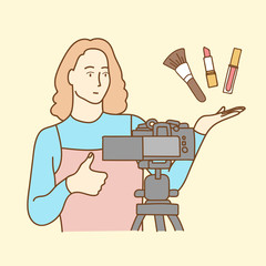 Camera recording a young female blogger reviewing cosmetic products while making a video
