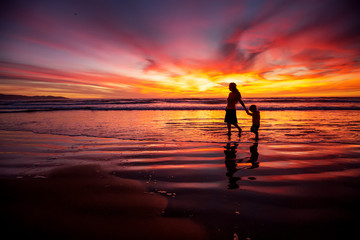 mother and son having fun at sunset on the beach