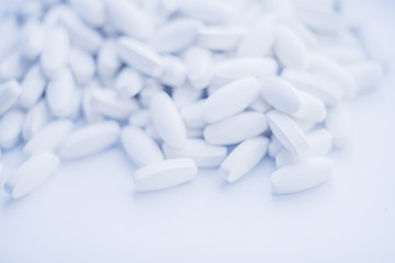 White pills heap blured background