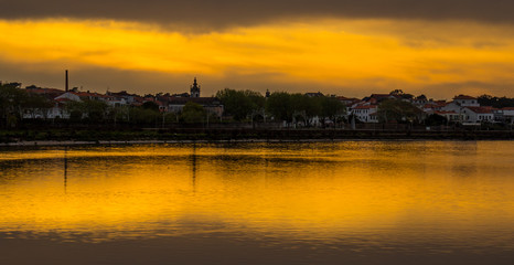 Naklejka premium Reflection of Fao Village in Cavado River at Sunset.