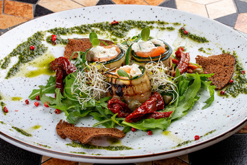 Eggplant rolls with salmon and Philadelphia cheese. With Arugula and sun-dried tomatoes