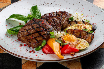 Grilled veal steak with vegetables and basil