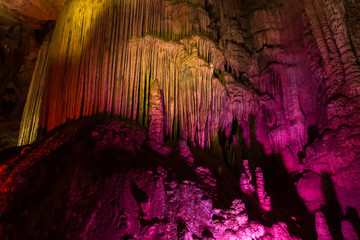 Colorful lighting of stalagmites in the cave of Prometheus, Georgia