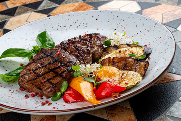 Grilled veal steak with vegetables and basil