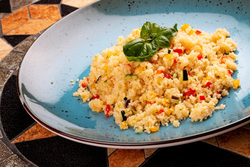 Couscous with vegetables in a ceramic decorative plate