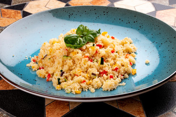 Couscous with vegetables in a ceramic decorative plate