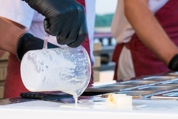 Chef cooking handmade natural asian stir-fried ice cream at freeze pan. Outdoor cooking, gastronomy and street food festival concept