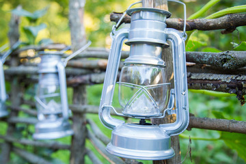 Rustic lanterns hanging on the wooden fence - street decoration and celebration concept