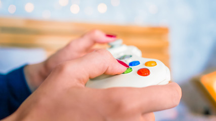 Gaming, hobby, technology and leisure time concept - woman playing video games with joystick or gamepad at home