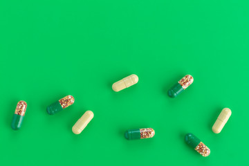 various capsules with antibiotics on a green background