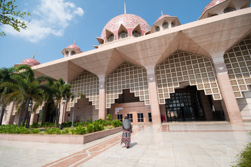 muslim woman in hijab is sightseeing Putrajaya Mosque during travel in Malaysia.