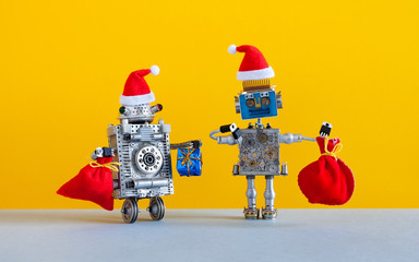 Robotic Christmas New Year greeting card. Two happy Santa Claus robots with a bags of Xmas gifts on yellow gray background. Winter holidays poster creative design toys