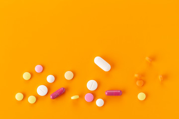 various tablets and capsules with antibiotics on a colored background