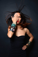 Young brunette lady with luxury accessories isolated on black background