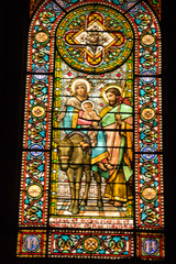 Montserrat, Spain, June 23, 2019: Stained glass window in the Benedictine monastery in Montserrat in Spain showing Jesus, Mary and Joseph with a donkey .