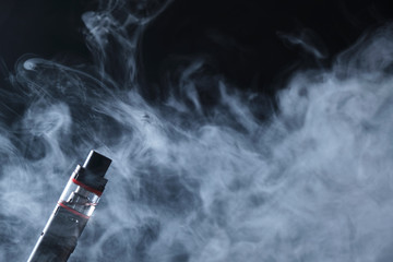 Electronic cogarette vape on a dark background with steam