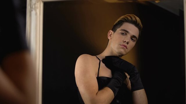 Agender in dress crying looking in mirror, feeling uncomfortable in male body