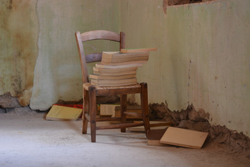 an abandoned house with books on the chair
