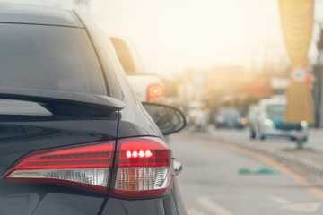 Luxury of black car stop on the asphalt junction by traffic light control in across. Traveling in the provinces during the bright period. Open light brake.