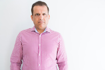 Fototapeta premium Middle age man wearing business shirt over white wall Relaxed with serious expression on face. Simple and natural looking at the camera.