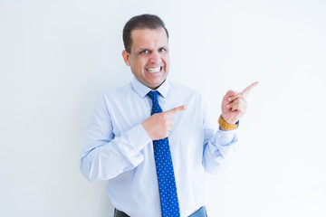 Middle age business man smiling and pointing to the side over white background