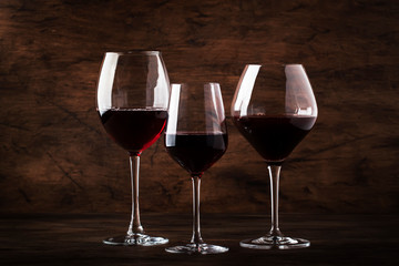 Selection of red wine on wine tasting. Dry, semi-dry, sweet red wines in special wine glasses on old wooden table background. Copy space