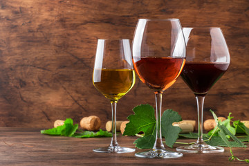 Wine set. Red, white and rose wine in assortment in wineglasses. Wine tasting, vintage wooden background, selective focus, copy space