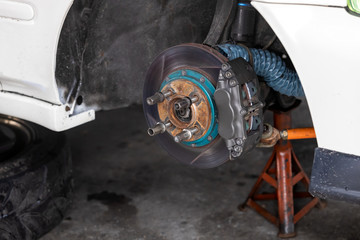 Maintenance car. Jacking up a car for changing tire in garage.