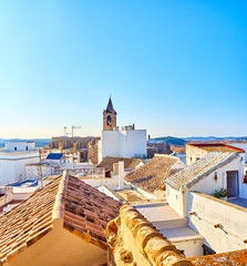 Rooftops view of Vejer de la Frontera downtown with the Bell tower of the Divino Salvador church in the background at sunset. Vejer de la Frontera, Cadiz province, Andalusia, Spain