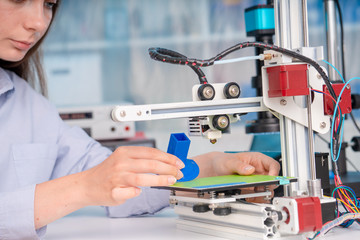 A student girl print prototype on 3D printer.