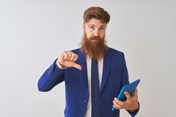 Young redhead irish businessman using tablet over isolated white background with angry face,...