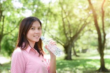 Woman Smile when drinking water with nature background